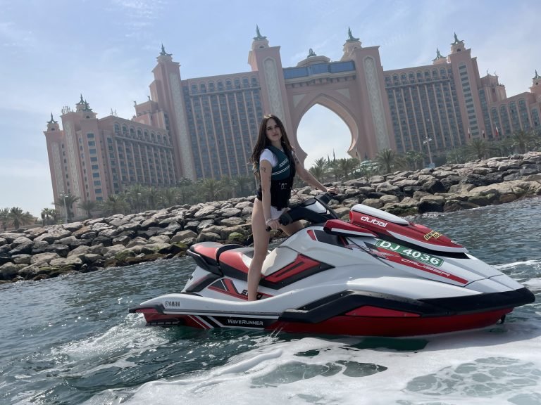 A girl posing on jetski in front of palm atlantis in Dubai ocean