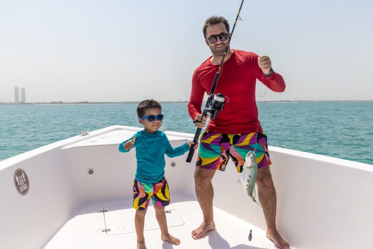A Man doing fishing with a little boy in yacht in Dubai