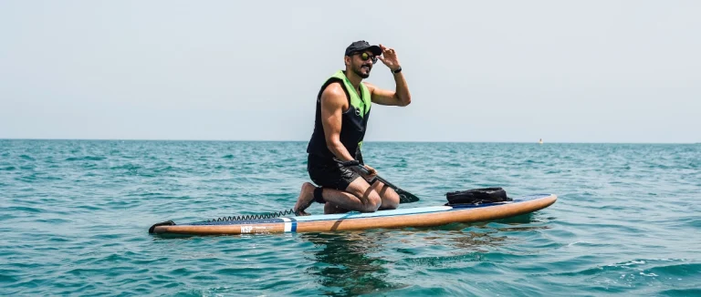 a man posing for photo on paddle board rental