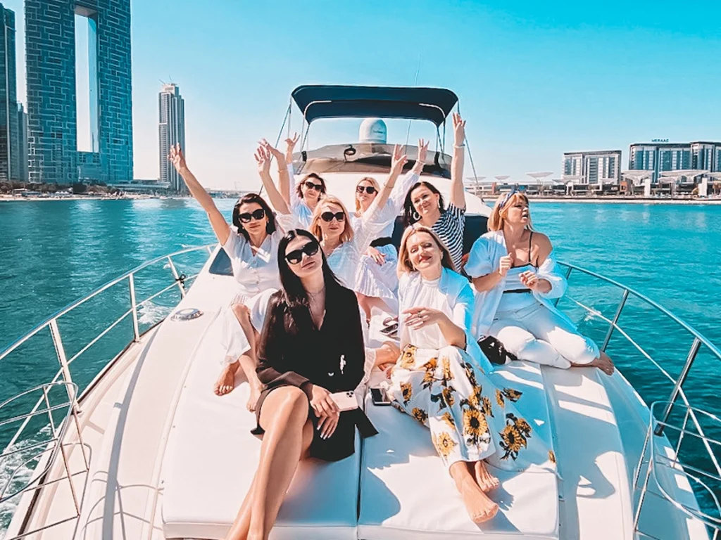 a bunch of men and women photo shoot on the deck of a yacht rental in dubai