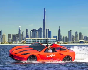 a man posing for photo in an orange color jet car in dubai with burj khalifa background view